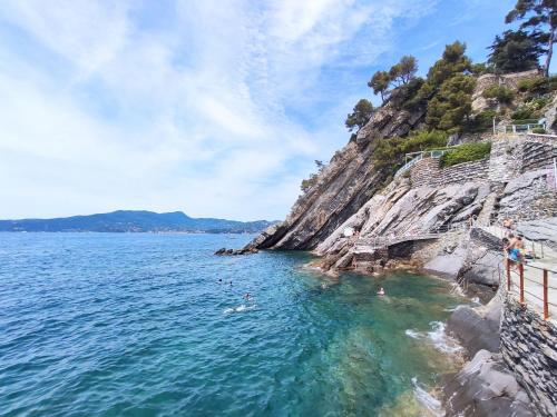 a beach with people swimming in the water at Studio Rosso by Interhome in Rapallo