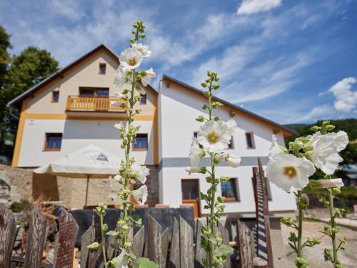 a house with white flowers in front of a fence at Apartment Marika 2 by Interhome in Cerny Dul