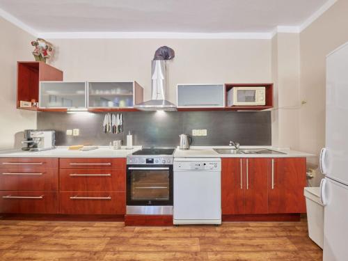 a kitchen with wooden cabinets and white appliances at Holiday Home Marika by Interhome in Černý Dŭl