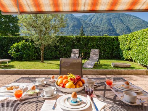 a table with a bowl of fruit on it at Apartment Stazione by Interhome in Porlezza