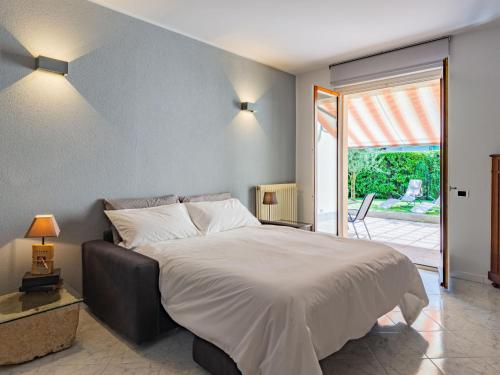 a bedroom with a large bed and a sliding glass door at Apartment Stazione by Interhome in Porlezza