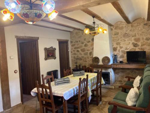 Acebos del Tajo في بيراليخوس دي لاس تروشاس: غرفة طعام مع طاولة وكراسي ومدفأة