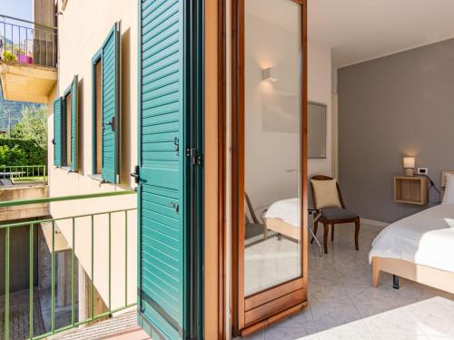 a room with a balcony with a bed and a window at Apartment Stazione by Interhome in Porlezza