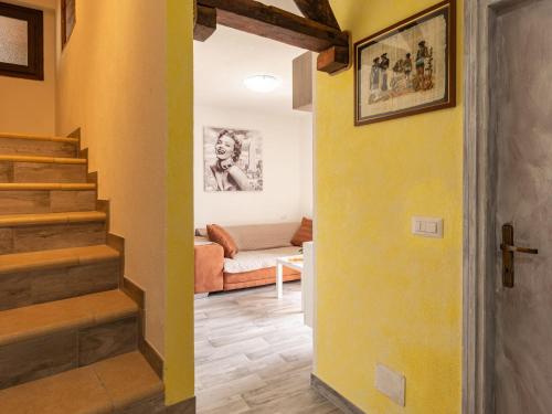 a living room with a yellow wall and stairs at Holiday Home Leonardo by Interhome in Albonico