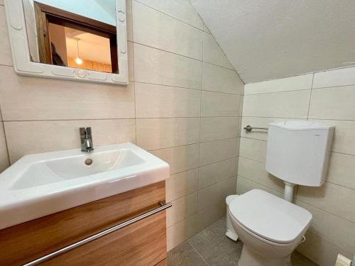 ein Badezimmer mit einem Waschbecken, einem WC und einem Spiegel in der Unterkunft Vintage-modern gem with private garden in Porto Santa Margherita