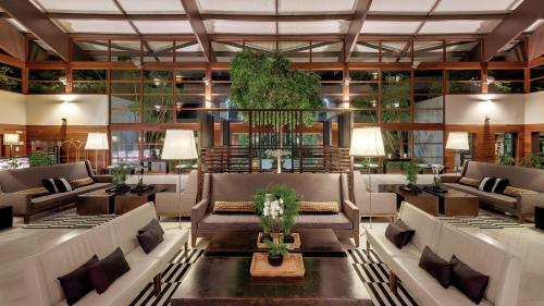 un vestíbulo con sofás y plantas en un edificio en Precise Resort El Rompido-The Hotel, en El Rompido
