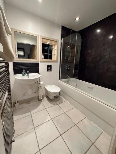 a bathroom with a toilet and a sink and a shower at Canary Wharf - Luxury Apartments in London