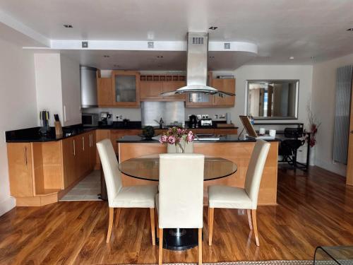 a kitchen and dining room with a table and chairs at Canary Wharf - Luxury Apartments in London