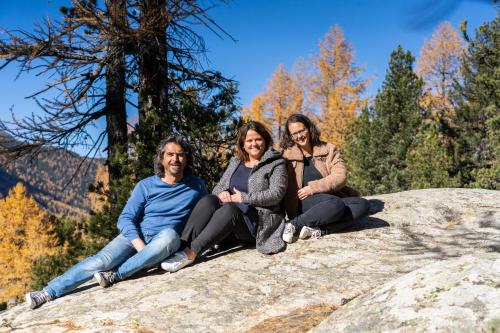 three people sitting on top of a rock at Hotel Garni Chesa Mulin in Pontresina