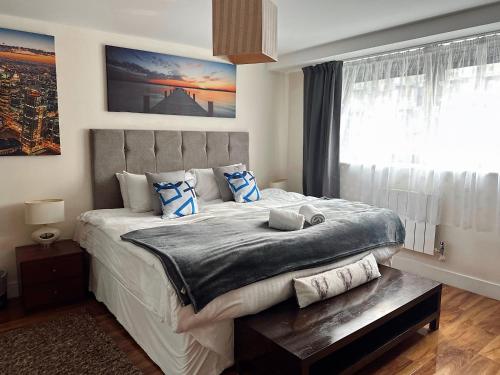 a bedroom with a large bed and a window at Canary Wharf - Luxury Apartments in London