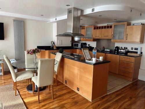 a kitchen with a table and a dining room at Canary Wharf - Luxury Apartments in London