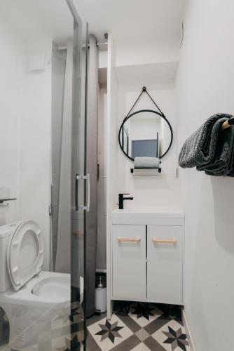 La salle de bains blanche est pourvue de toilettes et d'un miroir. dans l'établissement RÉPUBLIC’STUDIO AVEC PARKING !, à Nantes