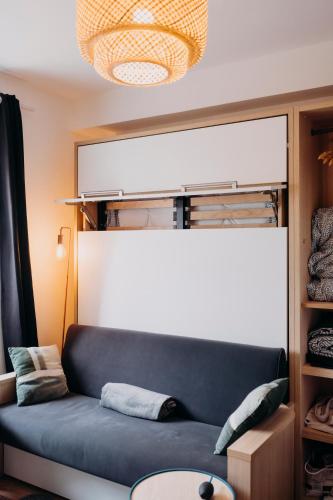 un salon avec un canapé bleu et une fenêtre dans l'établissement RÉPUBLIC’STUDIO AVEC PARKING !, à Nantes