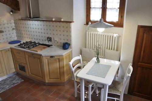 a kitchen with a table and a white table and chairs at Caty's little house in Cavriglia