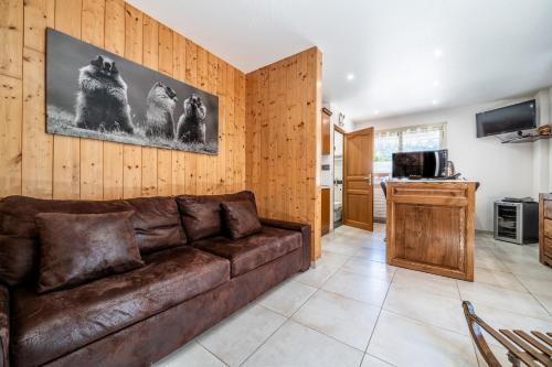 - un salon avec un canapé en cuir brun dans l'établissement Au Rêve Savoyard 3 - 6 personnes, à Morillon