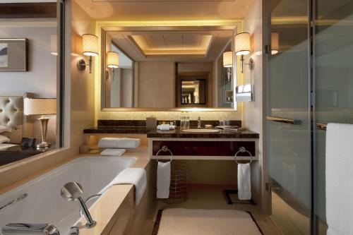 a bathroom with a tub and a sink and a mirror at Sheraton Changzhou Xinbei Hotel in Changzhou