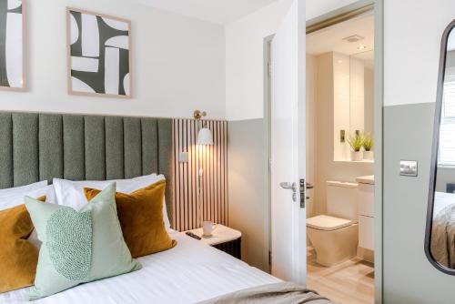 1 dormitorio con 1 cama con cabecero verde en Southwark Serviced Apartments I Your Apartment, en Londres