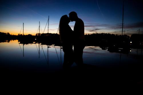a couple kissing in front of a body of water at Dufour Gib Sea 33 (Felice) in Hrdoňov