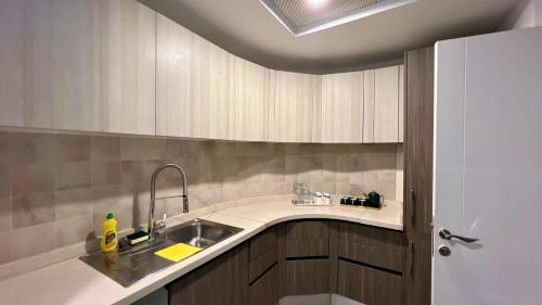 una cocina con armarios de madera y fregadero en Centaurus Apartment Mountain View Two Beds en Islamabad