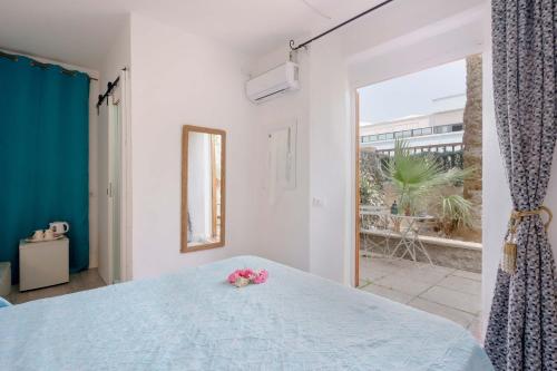 a bedroom with a blue bed and a large window at Villabeachcity Guesthouse in Cagliari