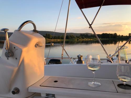una mesa con dos copas de vino en un barco en Dufour Gib Sea 33 (Felice), en Hrdoňov