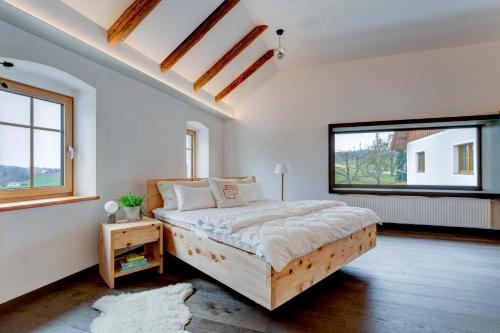 a bedroom with a bed and two windows at außergewöhnliches loft in ehemaligem stallgebäude 