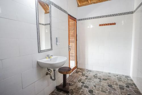 ein Bad mit einem Waschbecken und einem Spiegel in der Unterkunft Penida Lapaya Bungalows Nusa Penida in Nusa Penida
