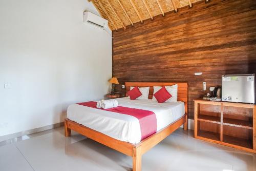 - une chambre avec un lit et un mur en bois dans l'établissement Penida Lapaya Bungalows Nusa Penida, à Nusa Penida