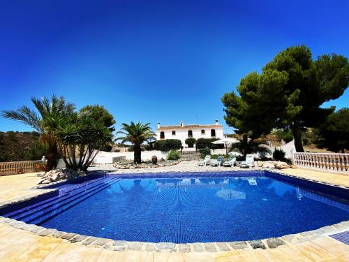 una piscina con una casa sullo sfondo di Hotel Los Sibileys a Puerto Lumbreras
