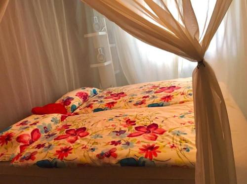 a bed with a comforter with flowers on it at Ruhige Wohnung Nähe Wörthersee in Klagenfurt