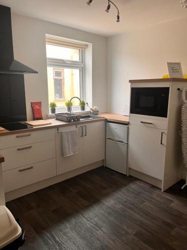 a kitchen with a sink and a microwave at The Oxfordshire in Blackpool