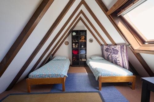 a attic room with two beds and a window at Le Tonneau Bleu - Appt avec piscine partagée in Lembach
