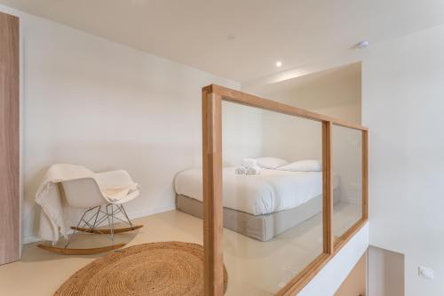 - un miroir dans une chambre avec un lit et une chaise dans l'établissement L'Authentique & Le Loft Duparc - 2 Studios de charme en centre ville, à Rennes