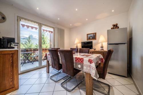 une cuisine et une salle à manger avec une table et un réfrigérateur dans l'établissement Au Rêve Savoyard 5 - 4 personnes, à Morillon