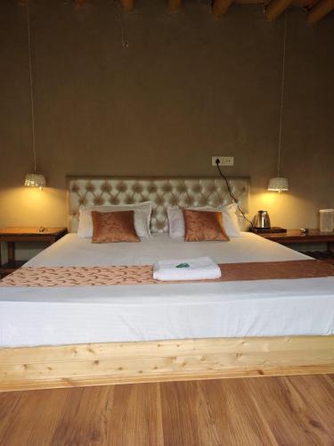 a bedroom with a large bed with white sheets at Skara Shangara Homestay in Leh
