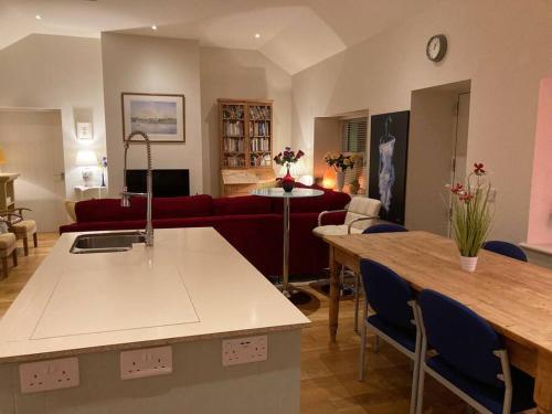 a kitchen and living room with a red couch at 2 Quay Road, Killala. Stunning Sea Front Cottage in Killala