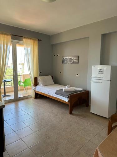 a bedroom with a bed and a refrigerator at Anna House Dhermi in Dhërmi