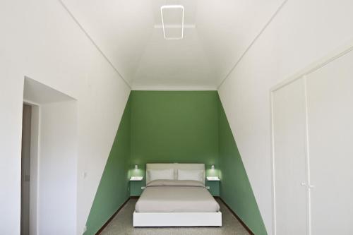 uma cama num quarto com uma parede verde em Residenza IL COLLE em Subiaco