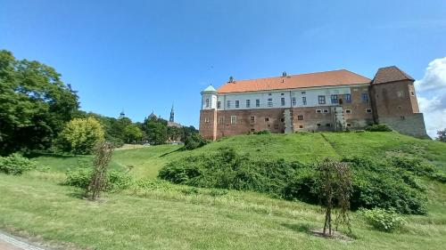 un gran edificio en la cima de una colina verde en Pokoje gościnne Sandomierz, en Sandomierz