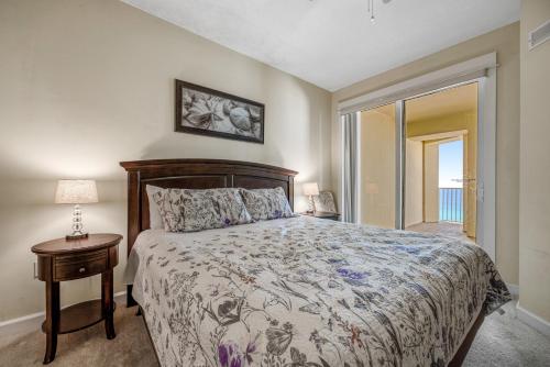 um quarto com uma cama e uma mesa com um candeeiro em Ocean Front Grand Panama 2 BD 2 BA Unit 1006, Spectacular Amenities em Panama City Beach