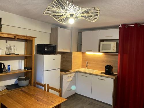 a kitchen with a white refrigerator and a table at Studio avec balcon amenage a Praz sur Arly in Praz-sur-Arly