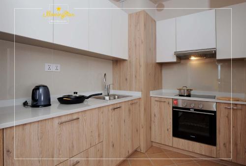 - une cuisine avec des placards blancs et un évier dans l'établissement Morning Star Residences Ulaanbaatar, à Oulan-Bator