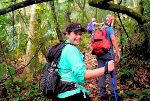 a group of people walking on a trail in the woods at Ba Be Jungle Houses in Ba Be