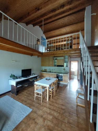 eine Küche und ein Esszimmer mit einem Tisch und einer Treppe in der Unterkunft Lago Ballano 