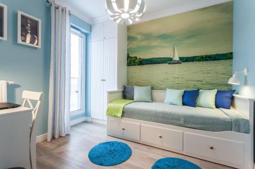 - une chambre dotée d'un lit avec une peinture murale sur voilier dans l'établissement Apartament MUSZELKA na Solnej 11 z garażem, à Kołobrzeg