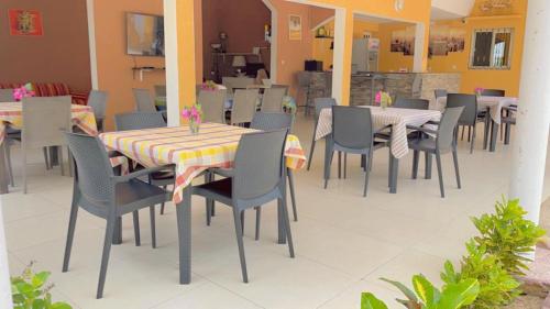 een eetkamer met tafels en stoelen in een restaurant bij Résidence Sophia in Fatick