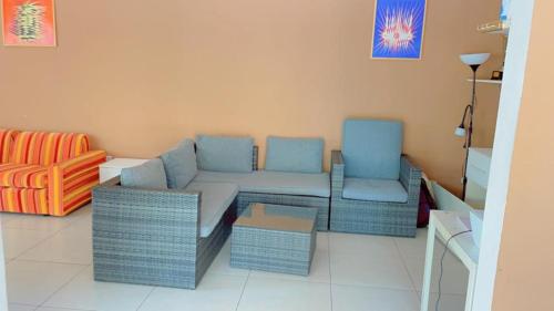 a living room with a couch and two chairs at Résidence Sophia in Fatick