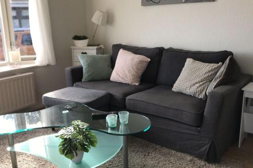 a living room with a couch and a glass table at Liefdevol chalet aan het meer in Suameer