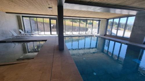 a large swimming pool in a building with windows at Ridge302 in Bourg-Saint-Maurice