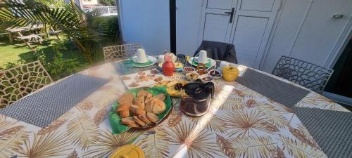 a table with a plate of food on it at Le Palmier de la Paix in Le Tampon